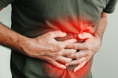 man clutching stomach in pain